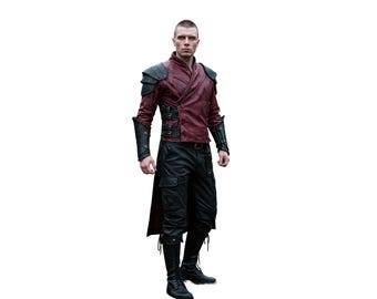 May include: A man wearing a red leather jacket with black accents and black pants. He is wearing black boots and has a short haircut.
