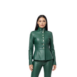 May include: A green leather jacket with a high collar and silver buttons. The jacket has a fitted silhouette and long sleeves. The model is also wearing matching green leather pants.