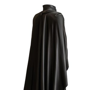 May include: A black cape with a high collar, draped over the shoulders. The cape is made of a smooth, flowing material, and the design suggests a gothic or theatrical theme. The cape is shown against a white background.