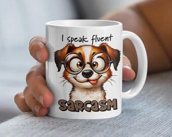 May include: White ceramic coffee mug with a cartoon dog wearing glasses and a tongue sticking out. The mug says "I speak fluent sarcasm".