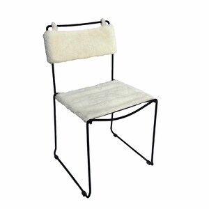May include: A modern chair with a black metal frame and a seat and backrest covered in a fluffy, off-white material. The chair's design is minimalist, with clean lines and a focus on comfort. The chair is suitable for various interior styles.