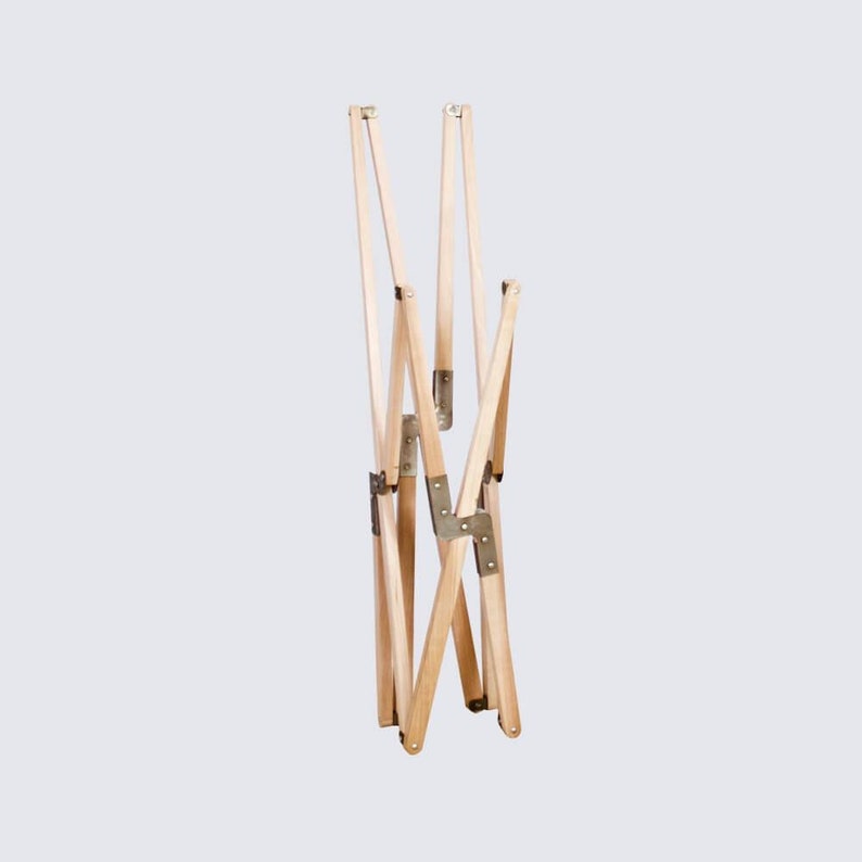 May include: A wooden folding chair frame with brass hinges. The frame is folded and ready for storage.