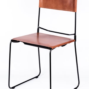 May include: A black metal chair with a brown leather seat and back.