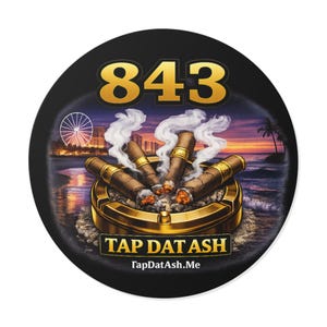 Op de afbeelding: Ronde zwarte onderzetter met een gouden "843" ontwerp. De onderzetter toont een asbak met brandende sigaren, rook en een zonsondergang strandscène. Tekst op de onderzetter luidt "TAP DAT ASH" en "TapDatAsh.Me".