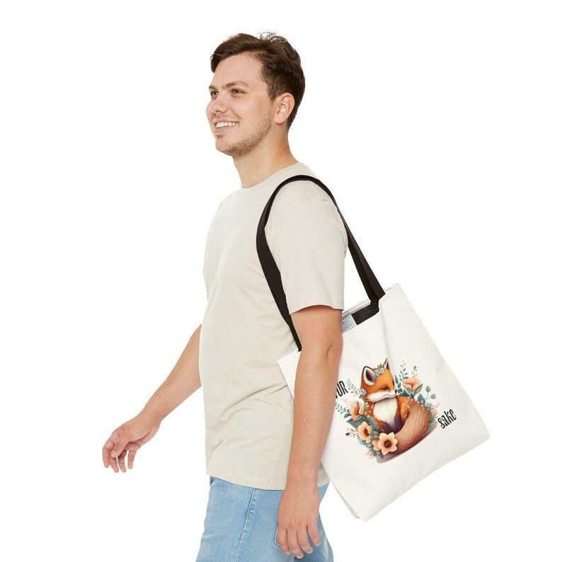 A man is walking with a white tote bag featuring a fox graphic on it.