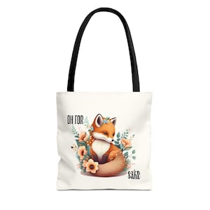 A white tote bag with a printed design of a fox surrounded by flowers and leaves.