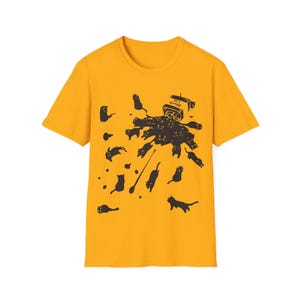 May include: Mustard yellow t-shirt with a graphic of black cats and a milk carton with the text "Black Cat". The cats are scattered around a dark brown splash.