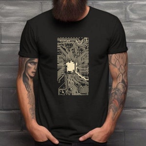 May include: A black t-shirt with a graphic print of a circuit board design in beige.
