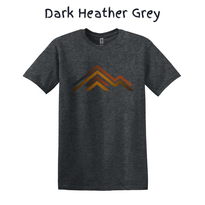 Puede incluir: Camiseta gris jaspeado oscuro con un dise&ntilde;o de monta&ntilde;a en tonos naranja y marr&oacute;n. El texto "Dark Heather Grey" est&aacute; encima de la camiseta. Una camiseta c&oacute;moda para el uso diario.