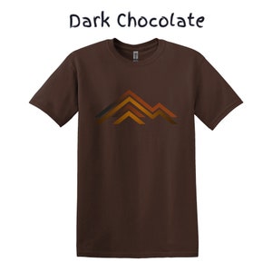 Puede incluir: Camiseta de color chocolate oscuro con un gr&aacute;fico de monta&ntilde;a en tonos naranja, marr&oacute;n y gris. El texto "Dark Chocolate" est&aacute; encima del gr&aacute;fico. Una camiseta de manga corta y cuello redondo.