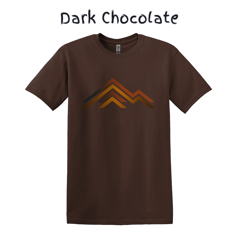 Puede incluir: Camiseta de color chocolate oscuro con un gr&aacute;fico de monta&ntilde;a en tonos naranja, marr&oacute;n y gris. El texto "Dark Chocolate" est&aacute; encima del gr&aacute;fico. Una camiseta de manga corta y cuello redondo.