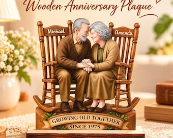 May include: A wooden anniversary plaque featuring a sculpted elderly couple sitting in two rocking chairs. The text reads Personalized Couple Wooden Anniversary Plaque and GROWING OLD TOGETHER SINCE 1975. The names Michael and Amanda are on the chairs.