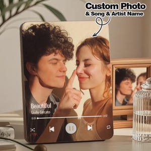 May include: A wooden plaque featuring a couple with the text "Beautiful" and the artist's name. The plaque has a music player interface design, with a play/pause button and song progress bar. The text "Custom Photo & Song & Artist Name" is also visible.