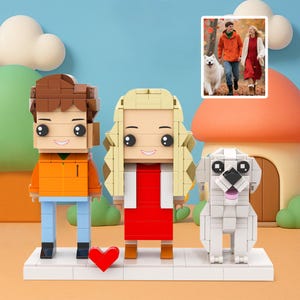 May include: A brick-built family scene featuring a couple and a dog, with a small photo insert of the real-life couple and dog. The figures have blocky features, with the couple in orange and red outfits. A red heart sits in front of them.