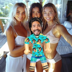 May include: A blue and white inflatable doll with a printed pattern of palm trees and faces. The doll is being held by three people, two women and one man. The women are wearing white bikini tops and the man is wearing a blue and white patterned shirt.