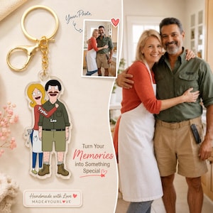 May include: A clear acrylic keychain featuring a cartoon illustration of a couple, with the names Taylor and Leo printed on their shirts. The keychain includes a gold-toned metal ring and clasp, and is displayed alongside a photograph of the couple.