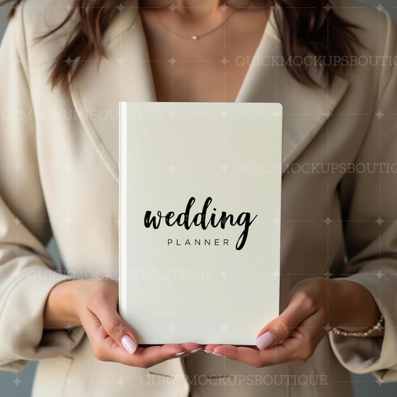 May include: A white planner with the text "wedding planner" in black cursive writing.