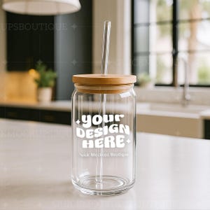 May include: A clear glass tumbler with a bamboo lid and a glass straw. The tumbler has a white design that says "your design here" and "Quick Mockups Boutique".