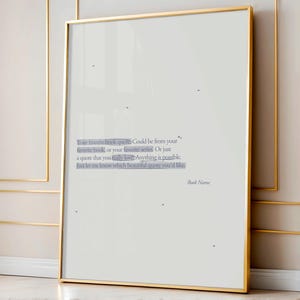 May include: A framed print with a gold border. The print features text in a light blue font on a white background. The text reads: "Your favorite book quote...Anything is possible. Just let me know which beautiful quote you'd like." The words "Book Name" are at the bottom.
