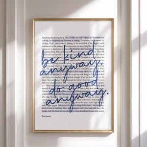 May include: A framed art print with a gold frame. The print features a background of black text with the words "be kind anyway, do good anyway" in blue cursive script. The word "Beartown" is at the bottom.