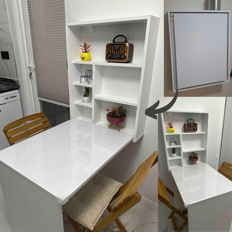 May include: White folding wall-mounted table with shelves. The table is down and has two chairs. The table is white with a glossy finish. The shelves are white and have a variety of items on them, including a radio, plants, and a small shelf.