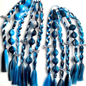 May include: Two sets of blue, black, and white braided hair extensions. Each set features multiple braids with decorative beads, bows, and long, layered tassels. The color scheme includes shades of blue, black, and white.