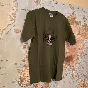 May include: A green t-shirt with a black and white skull graphic and the word "PHANTOM" printed below it.