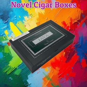 Könnte beinhalten: Eine schwarze rechteckige Zigarrenkiste mit dem Text Novel Cigar Boxes oben. Der Deckel hat ein grünes Etikett mit dem Text JAVA by Drew Estate, Premium Mint und Long Filler. Ein weißes Warnetikett befindet sich an der Ecke der Kiste.