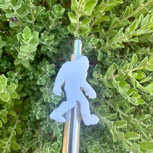 May include: A white plastic Bigfoot figure attached to a silver metal vape pen.