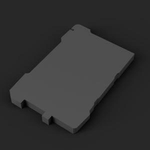May include: A solid dark grey rectangular object with a flat surface and notched edges. The item features a small protruding tab on one of the shorter sides and a series of symmetrical indentations along the perimeter of its frame.