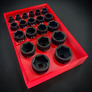 Puede incluir: Una bandeja organizadora de plástico rojo que contiene un juego de vasos de impacto hexagonales de metal negro. Cada vaso está etiquetado con su tamaño específico en pulgadas, desde los más pequeños arriba hasta los más grandes abajo.