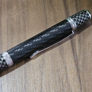 Penna a spirale in tonalità di fibra di carbonio nera fusa in resina trasparente con puntale in fibra di carbonio sintetica e impugnatura affusolata con dettagli cromati