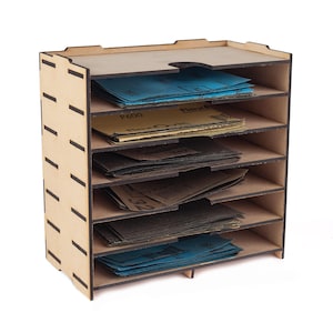 May include: A wooden organiser with six shelves, each holding sheets of sandpaper in various colours. The organiser is made of light brown wood and has a cutout on the top shelf. The sandpaper sheets are labelled with numbers and the brand name Flex.