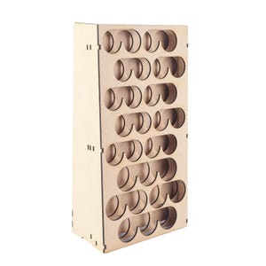 May include: A light-coloured wooden paint bottle organiser with multiple circular openings. The organiser is rectangular and designed to hold small bottles, likely for art supplies or crafts. The wood has a natural finish.