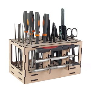 Puede incluir: Un organizador de herramientas de madera lleno de varias herramientas manuales. Las herramientas incluyen destornilladores con mangos negros y naranjas, limas, pinzas, tijeras y otros instrumentos pequeños. El organizador es de madera marrón claro y tiene múltiples compartimentos.