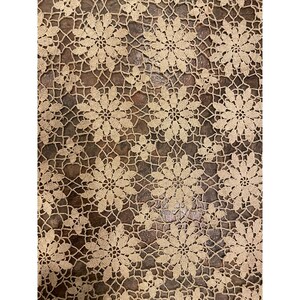 May include: A beige crocheted tablecloth with a repeating pattern of floral designs.