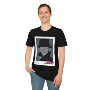 May include: A black t-shirt with a graphic print of a person wearing a hat with a swirling pattern over their face. The text "my strange honey" is printed below the graphic.