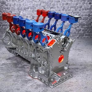 Könnte beinhalten: Ein detaillierter, silberfarbener Motorblock mit roten und blauen Kolben. Die Kolben sind in einer Reihe angeordnet, mit abwechselnden roten und blauen Farben. Der Motorblock hat detaillierte mechanische Komponenten und eine polierte Oberfläche.