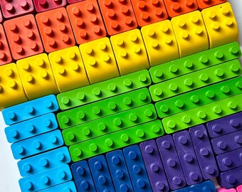 May include: A collection of rectangular plastic building blocks arranged in a grid pattern. The blocks feature circular studs on the top surface and come in a variety of colors including red, orange, yellow, green, blue, purple, pink, and brown.