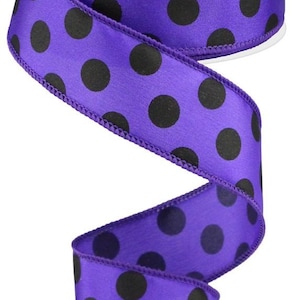 May include: Purple satin ribbon with black polka dots. The ribbon is 2.5 inches wide and has a wired edge.