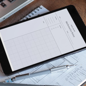 May include: A black tablet displaying a mathematics notes template with grid lines, the text "THESE ARE MY Mathematics Notes", and sections for class, date, and work. A mechanical pencil and notebook are in the foreground.