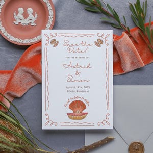 Könnte beinhalten: Save the Date Karte mit weißem Hintergrund und roten und orangen Akzenten. Die Karte zeigt eine Muschel-Illustration und den Text "Save the Date!" für die Hochzeit von Astrid & Simon am 14. August 2025 in Porto, Portugal.
