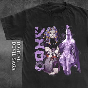 May include: Black t-shirt with a purple graphic from the "Digital Devil Saga" series. The design features a female character with purple hair and a stylized figure. Japanese text is also included.