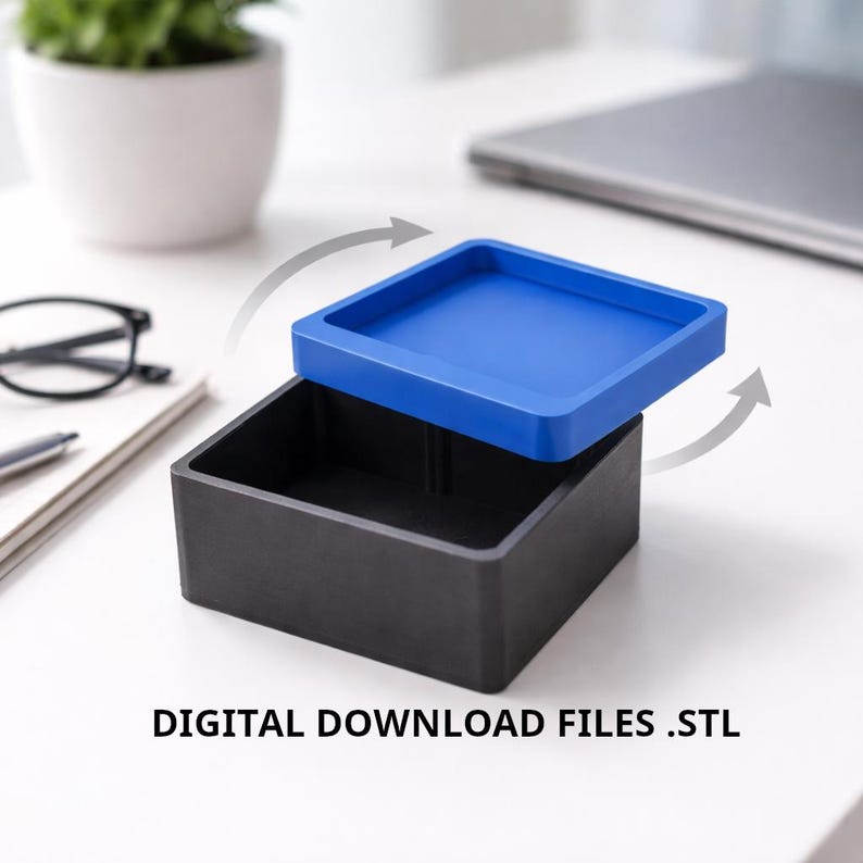 May include: A black square box with a blue lid, partially open, sits on a white surface. The lid is a vibrant blue, contrasting with the dark box. The text "DIGITAL DOWNLOAD FILES .STL" is at the bottom.