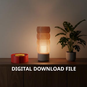 May include: A modern table lamp with a cylindrical, layered shade in shades of orange and beige, resting on a gray base. A red and yellow container sits to the left. The text "DIGITAL DOWNLOAD FILE" is at the bottom.
