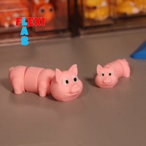 May include: Two pink pig figurines with movable body parts. The larger pig has a head, body, and tail that can be moved. The smaller pig has a head and body that can be moved.