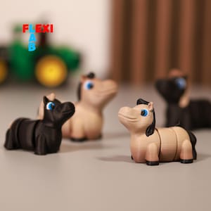May include: Four small, articulated toy horses in various shades of tan and black, with blue eyes and black manes. The word "FLEXI" is visible in the background. The toys are designed to be flexible and poseable.