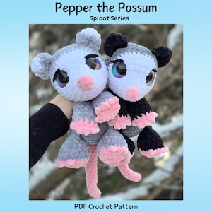 Puede incluir: Dos juguetes de peluche de zarigüeya, uno gris y blanco, el otro negro y blanco, con detalles rosas en las patas y colas. Los juguetes tienen grandes ojos iridiscentes y están etiquetados como "Pepper the Possum" y "PDF Crochet Pattern".