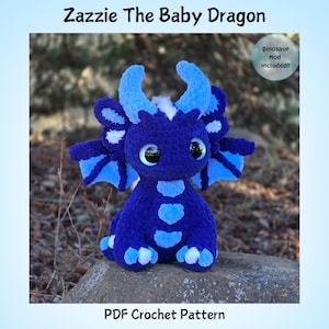 May include: A handcrafted blue crochet dragon toy with large, expressive eyes. The dragon features light blue accents on its horns, wings, and belly. The text "Zazzie The Baby Dragon" and "PDF Crochet Pattern" are displayed.