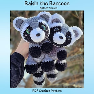 Può includere: Due peluche di procione all'uncinetto, con filato nero, grigio e bianco. I procioni hanno occhi neri, code a strisce grigie e bianche e il testo "Raisin the Raccoon" e "Sploot Series" in alto. La parte inferiore dell'immagine recita "PDF Crochet Pattern".